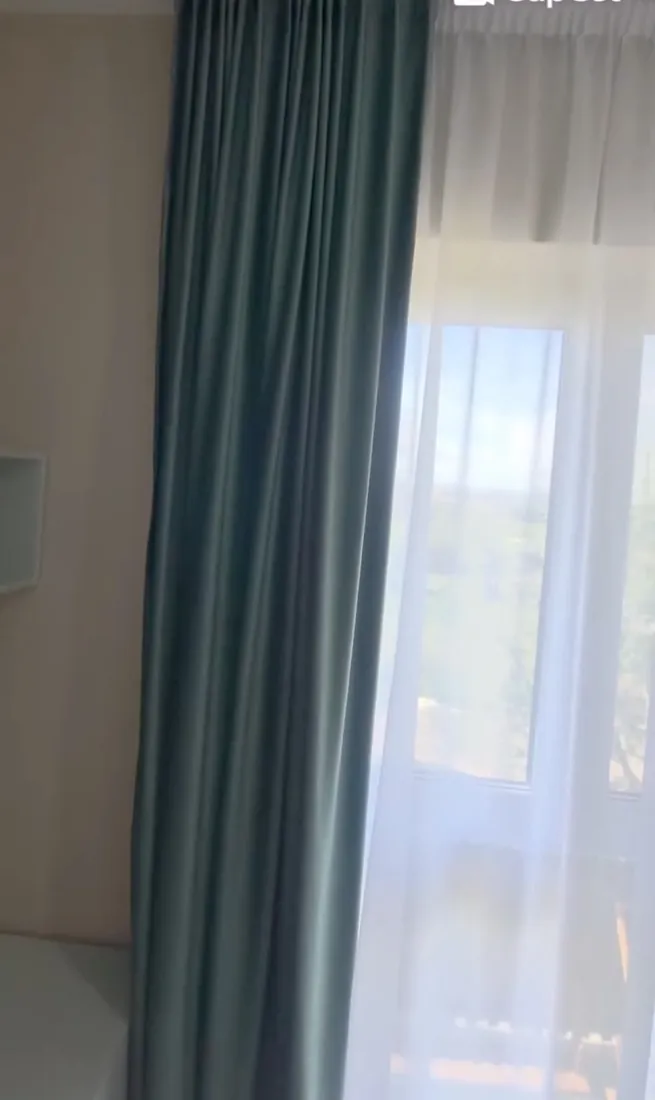 Draperie verde lângă voal alb, într-un apartament luminos
