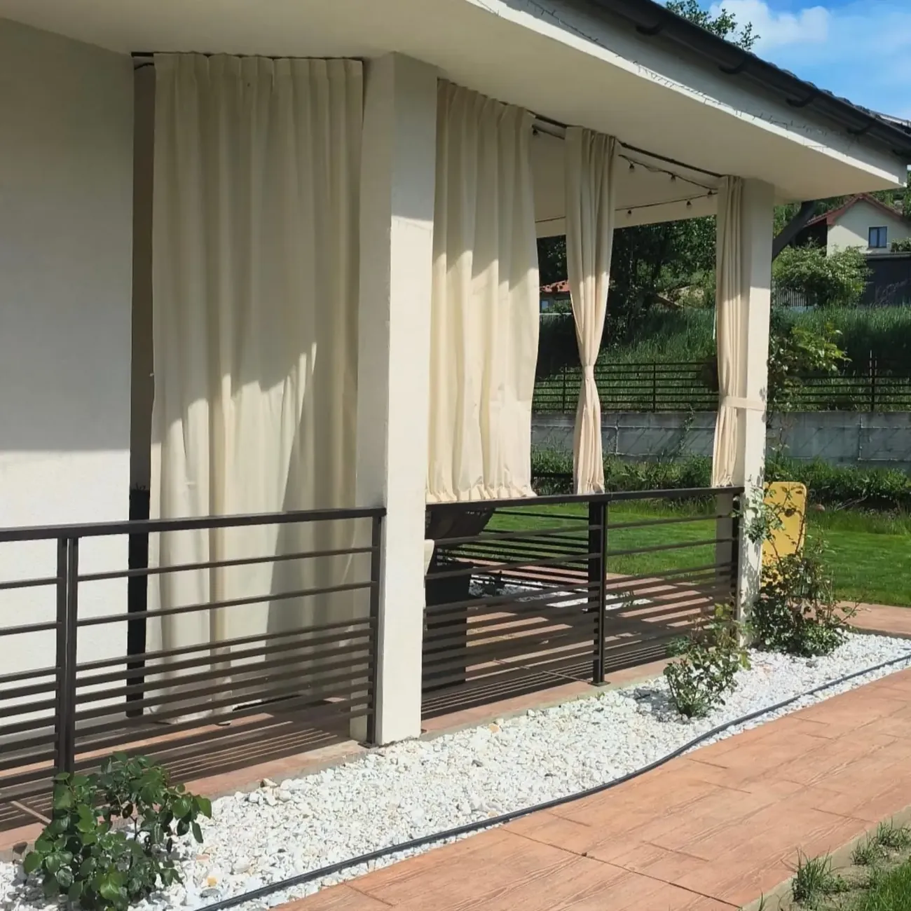 Draperii exterioare albe pe o terasă